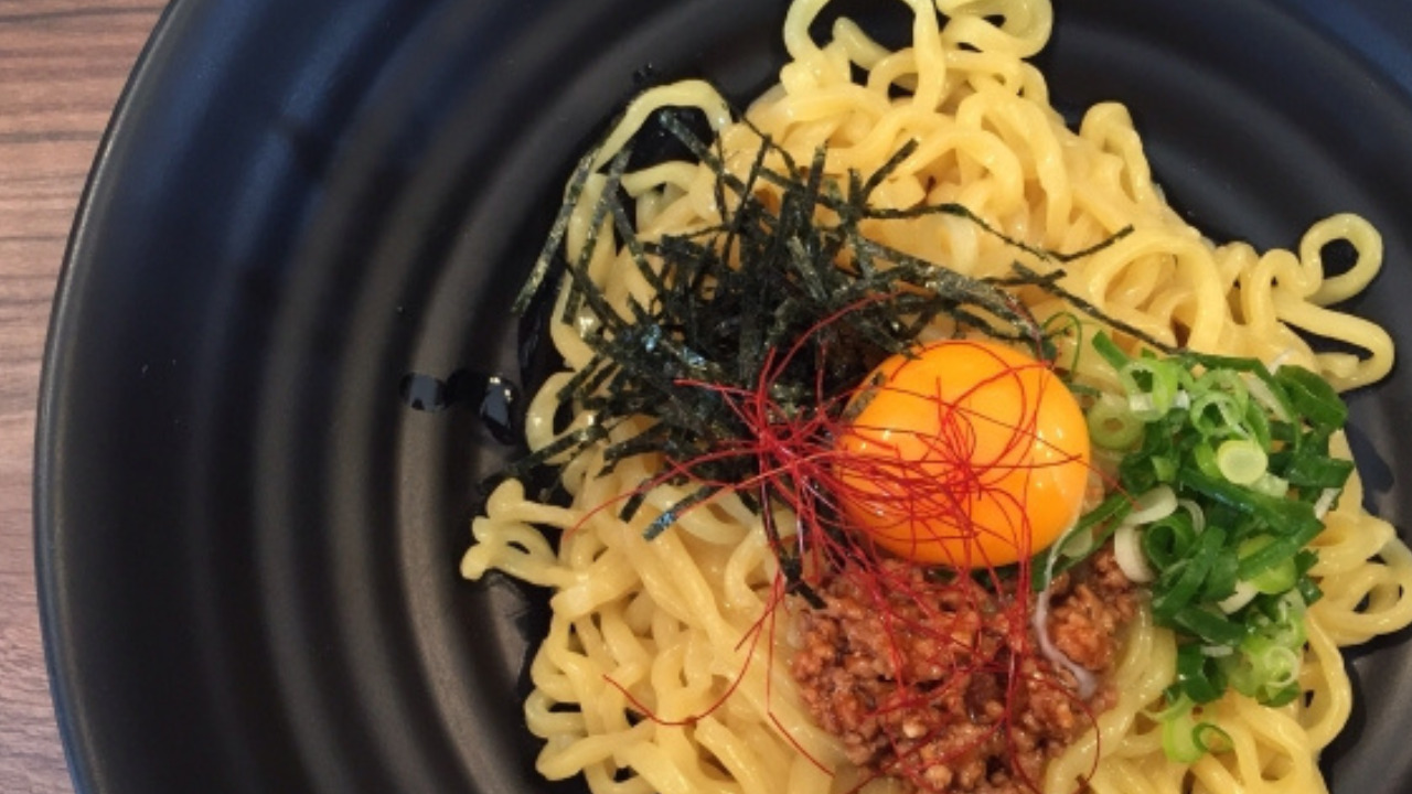 卵黄、ねぎ、肉が乗った麺